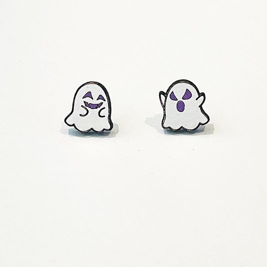 A pair of mismatched ghost-themed stud earrings featuring playful cartoon-style designs. One earring shows a smiling white ghost with closed, happy eyes and a cheeky grin in purple. The other displays a surprised ghost with raised arms and wide, startled purple eyes and mouth. Both ghosts have a simple rounded shape with scalloped bottoms and are outlined in black. The earrings are lightweight, flat, and appear to be made of a glossy material, ideal for Halloween wear.